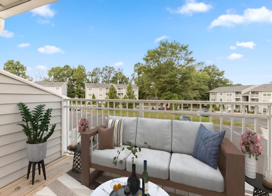 a patio with a couch and a table on a balcony at West Pointe Apartments in Burlington, NC