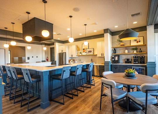 A modern kitchen with a large island and bar stools. at Arbour Commons, Westminster, CO