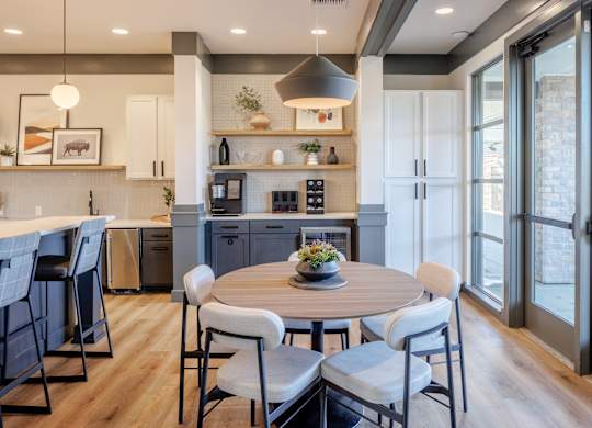A modern kitchen with a dining table set for four. at Arbour Commons, Westminster, CO