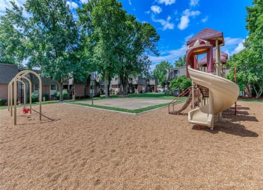 a playground with a slide at an apartment complex