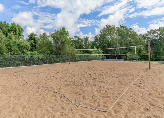 a volleyball court on a dirt field in front of trees