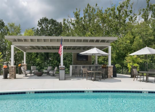 a poolside pavilion with an outdoor entertaining area and a swimming pool