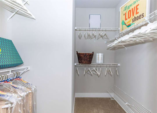 a walk in closet with a door to a closet filled with clothes