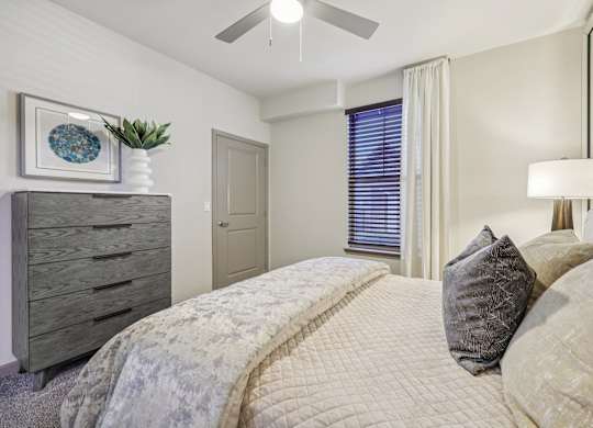 bedroom with large bed and a dresser at Vine + Vail Townhomes and Apartments, Grapevine, TX 76051