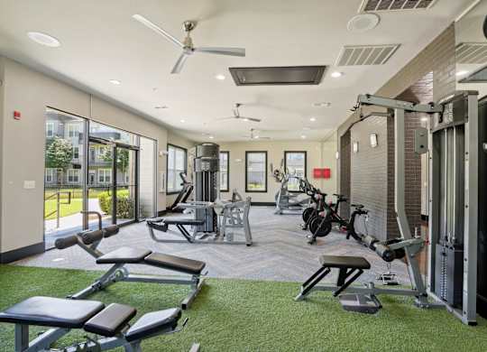 A gym with a variety of equipment including weights and cardio machines.