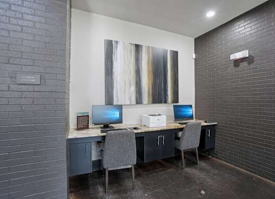 A room with a desk and two computers.