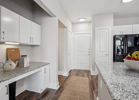 Galley kitchen with granite counters and white cabinetry at Highline Urban Lofts Apartments, Cypress