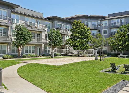 Courtyard with sand volleyball court and seating areas at Highline Urban Lofts Apartments, Texas