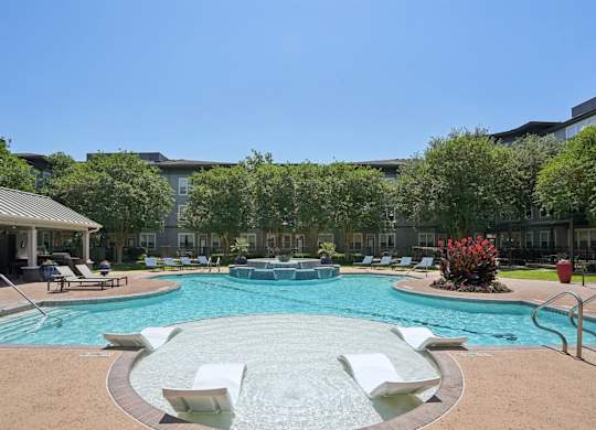 Poolside tanning shelf with lounge chairs and spa at Highline Urban Lofts Apartments, Texas