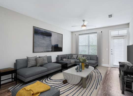 Modern living room with sectional sofa and abstract artwork at Highline Urban Lofts Apartments, Texas