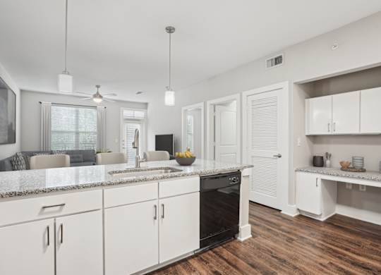 White kitchen with granite countertops and open layout at Highline Urban Lofts Apartments, Cypress, Texas