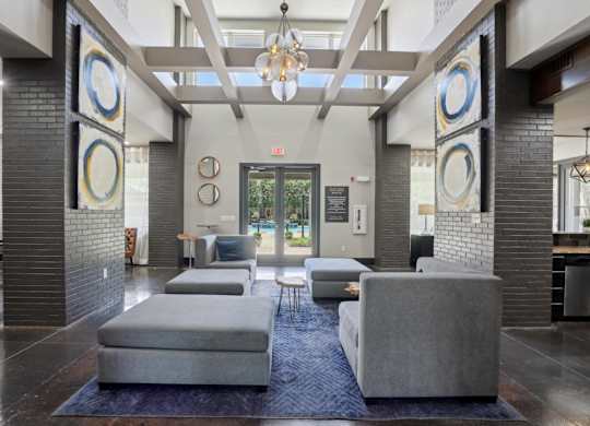 Modern clubhouse lobby with coffered ceiling and lounge seating at Highline Urban Lofts Apartments, Cypress, Texas