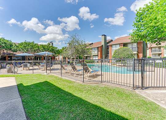 A sunny day at the poolside with a building in the background at Bardin Oaks Apartments, Arlington, TX