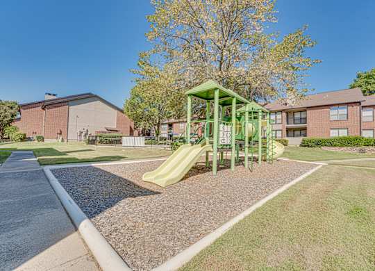 Playground with a green slide at Bardin Oaks Apartments, Texas