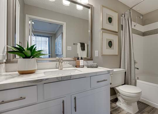 Modern bathroom with white vanity and marble countertop at Carmel Creekside Apartments, Texas, 76137