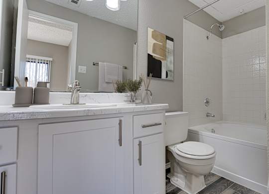 Bathroom with tub shower combo and white cabinetry at Carmel Creekside Apartments, Fort Worth, TX 76137