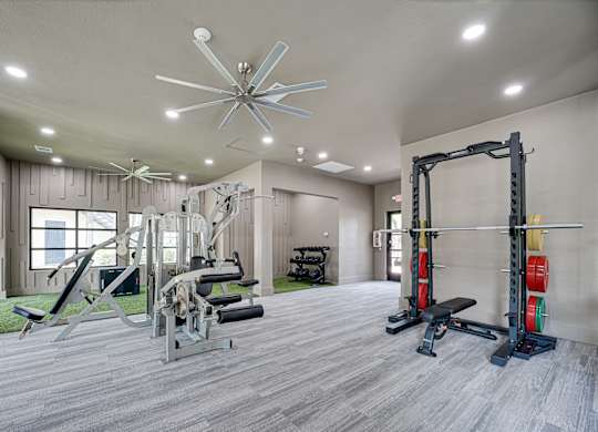 Fitness center with power rack and weight machines at Carmel Creekside Apartments, Fort Worth