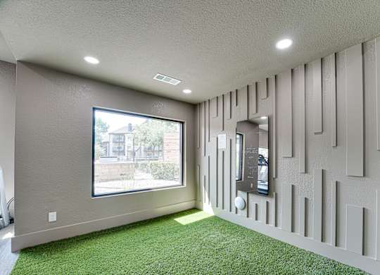 Indoor pet area with artificial turf and modern wall panels at Carmel Creekside Apartments, Fort Worth, TX
