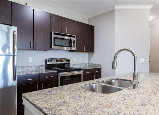 A kitchen with granite countertops and stainless steel appliances.