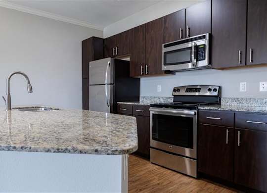 A kitchen with granite countertops and stainless steel appliances.