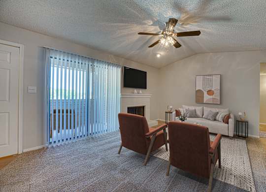 A living room with a fireplace and a television at Indian Creek Apartments, Carrollton 75007
