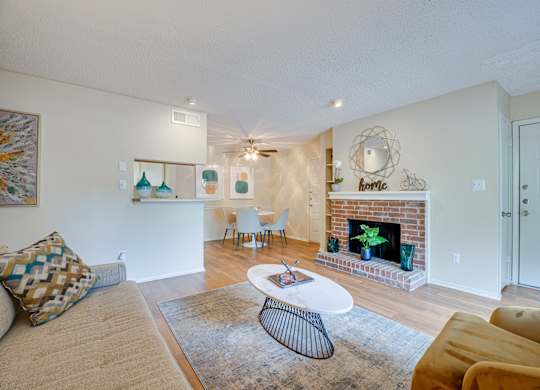 a living room with a fireplace and a couch and a table at Indian Creek Apartments, Texas