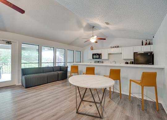 a living room with a round table and a kitchen with a couch at Indian Creek Apartments, Carrollton