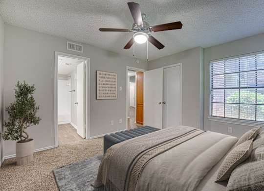 Bedroom with ceiling fan, and a potted plant. at Timberglen Apartments, Texas