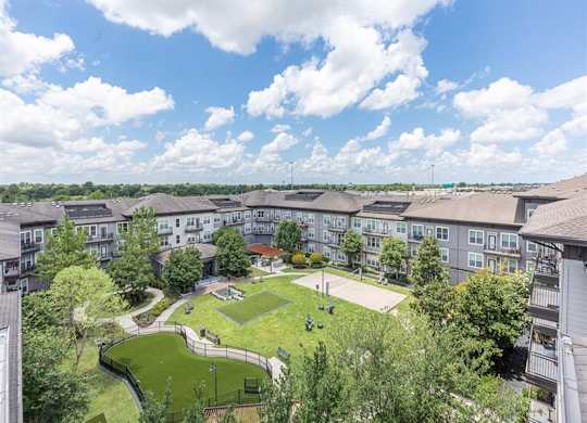 Aerial view of courtyard with green space and pathways at Highline Urban Lofts Apartments, Texas, 77429