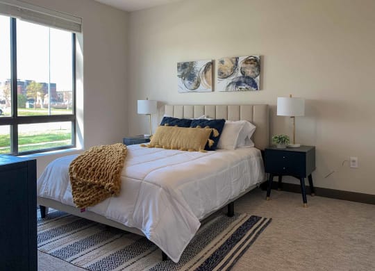 a bedroom with a bed and a large window