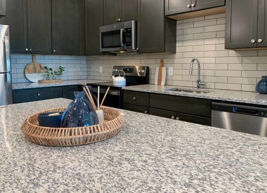 a decorative wicker tray on the granite counter top of the kitchen island