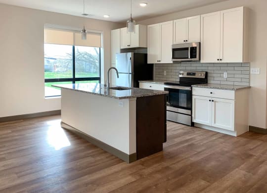 a kitchen with white cabinets and granite countertops