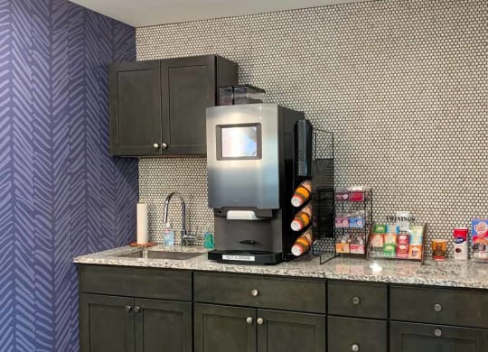 A coffee bar featuring an espresso and latte maker, tea station, and creamers and sugar