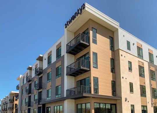 the corner of a four-story brick apartment building with balconies