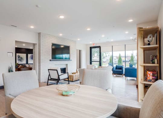 a table surrounded by chairs in the clubhouse lounge space