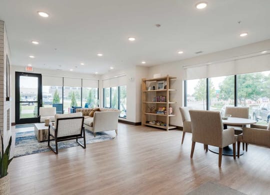 a community room with a table and chairs and seating in front of the fireplace