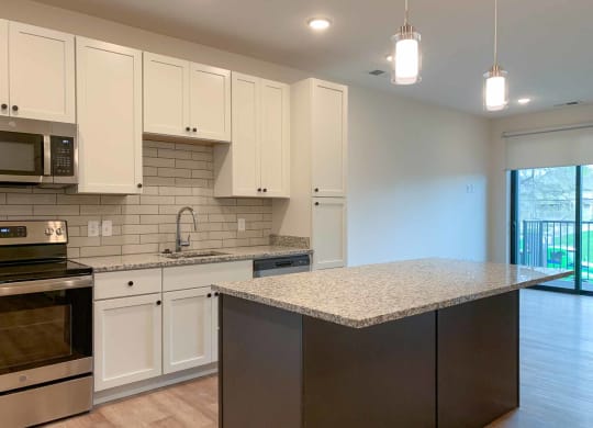 a kitchen with white cabinets and large island
