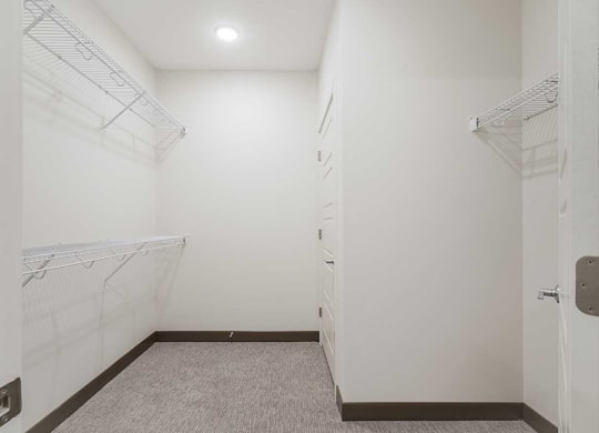 a large walk in closet with built in shelving