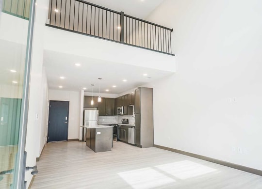 a view of the living room, kitchen, and upper loft area from the patio door