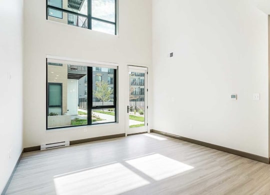 a living room with a two-story wall of windows and luxury vinyl tile flooring