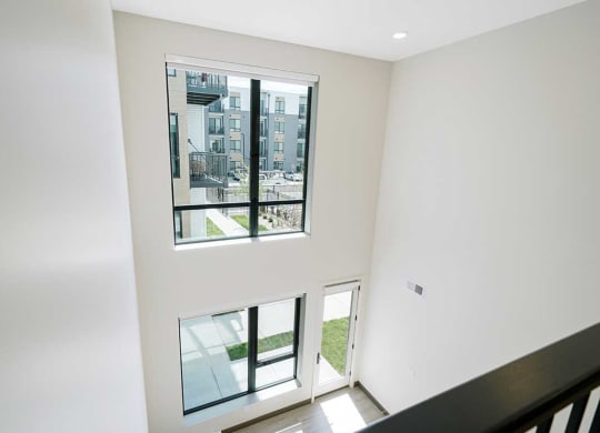 a two-story wall in the living room with floor to ceiling windows