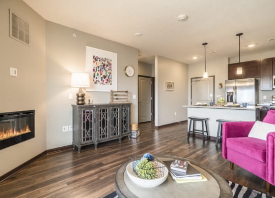 One bedroom apartment living room with modern fireplace and hardwood-style floors at 360 at Jordan West best new apartments West Des Moines IA 50266