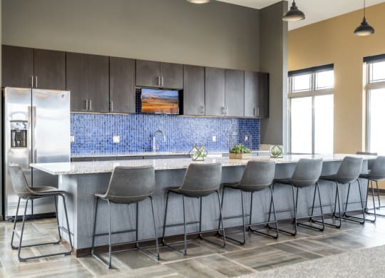 Kitchen with barstools and fridge for residents to use in the clubhouse at 360 at Jordan West best new apartments West Des Moines IA 50266