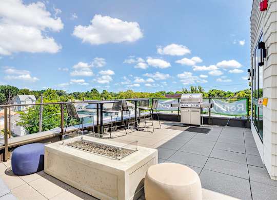 A patio with a grill and seating area.