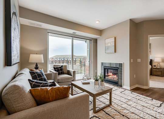 A living room with a couch, a coffee table, and a fireplace.