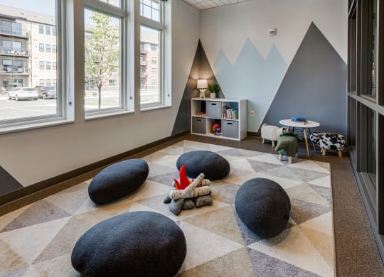 Kids room with storage shelf, plush seating and a toy fire