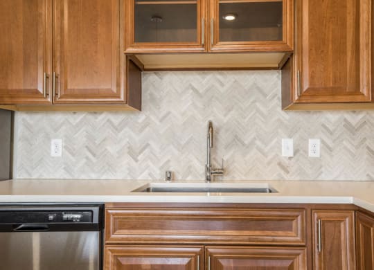 Ascend at Woodbury luxury apartment with herringbone backsplash in kitchen