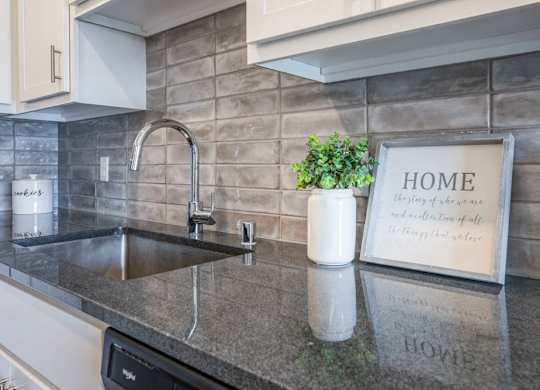 Designer Grohe-brand faucets, granite countertops and kitchen backsplash at Ascend at Woodbury MN 55129 new luxury apartments