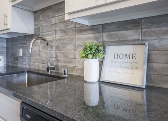 Designer Grohe-brand faucets, granite countertops and kitchen backsplash at Ascend at Woodbury MN 55129 new luxury apartments