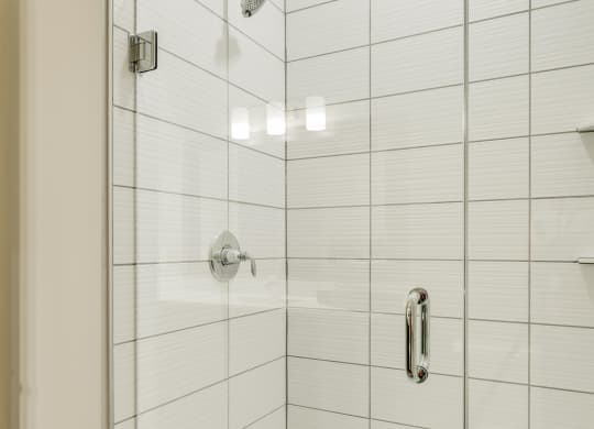 Shower with subway tile and glass doors at Ascend at Woodbury in MN
